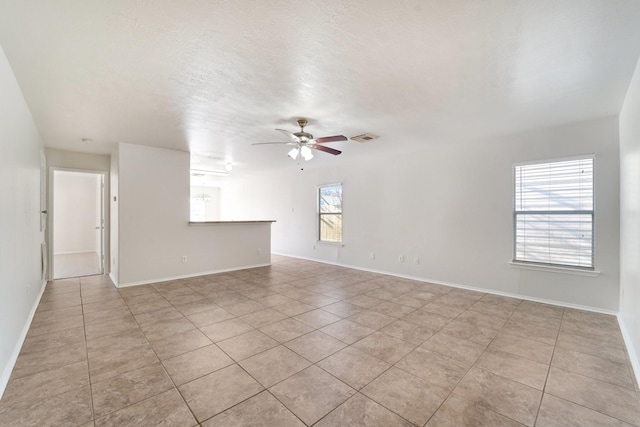 tiled spare room with ceiling fan and a textured ceiling