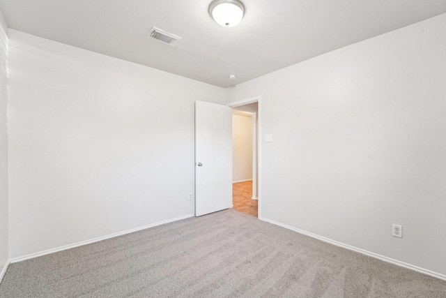 spare room featuring light colored carpet