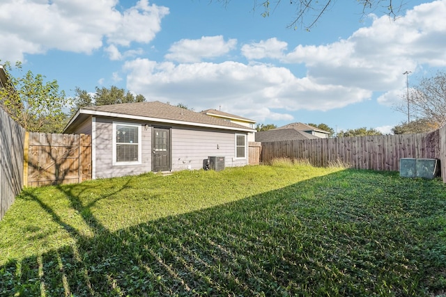 rear view of house featuring a lawn and cooling unit