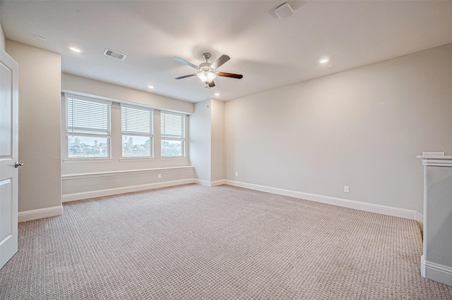 empty room featuring ceiling fan and light carpet