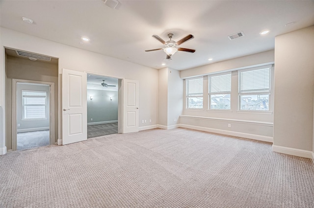 unfurnished bedroom with ceiling fan, light colored carpet, and multiple windows