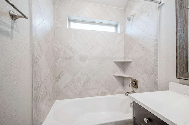 bathroom with tiled shower / bath and vanity