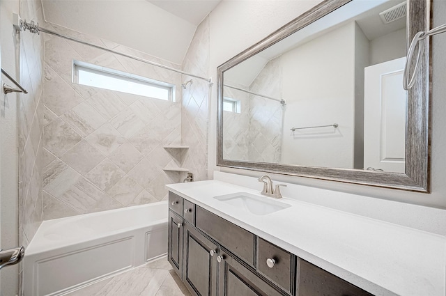 bathroom featuring tiled shower / bath combo and vanity