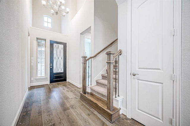 entrance foyer featuring hardwood / wood-style floors, a high ceiling, and a notable chandelier