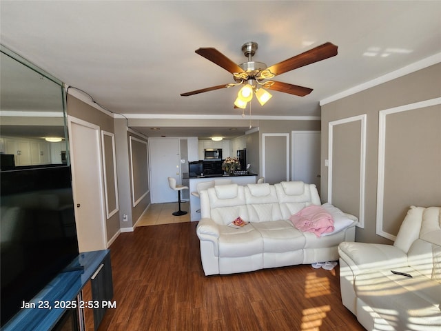 living room featuring crown molding, dark wood-type flooring, and ceiling fan