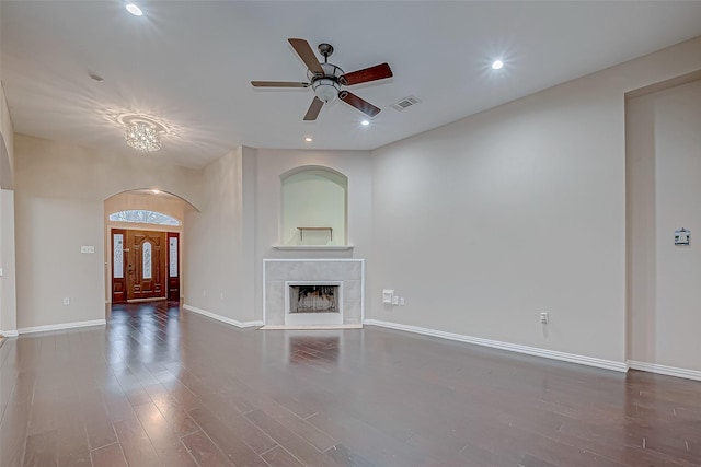 unfurnished living room featuring a tiled fireplace, hardwood / wood-style flooring, and ceiling fan