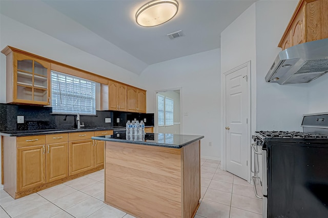 kitchen with a center island, light tile patterned floors, ventilation hood, gas stove, and plenty of natural light