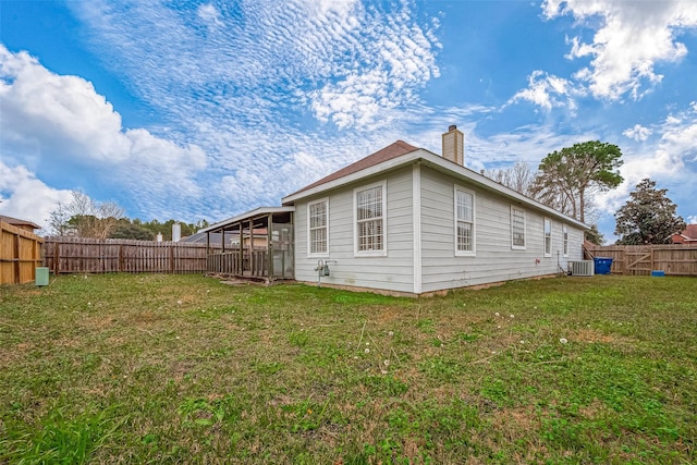 rear view of property featuring a lawn and central AC