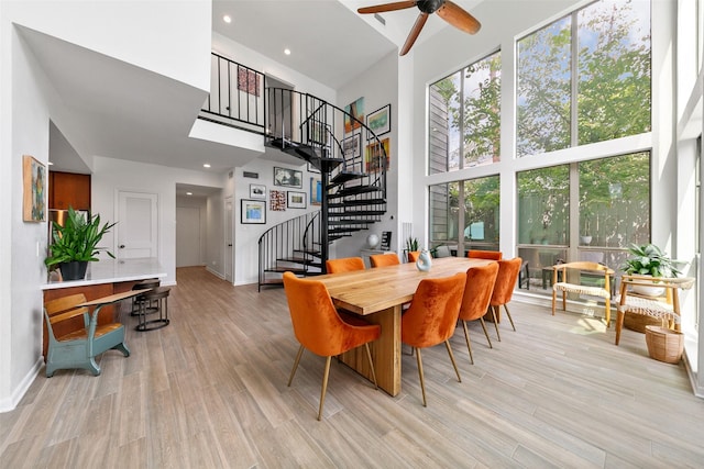 dining area featuring ceiling fan and a high ceiling