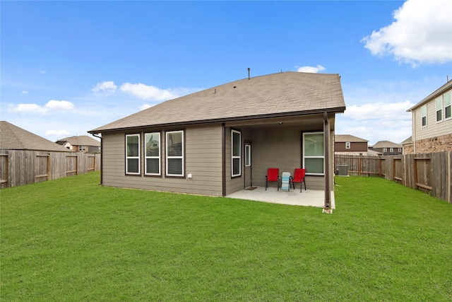 rear view of property featuring a yard, central AC unit, and a patio area