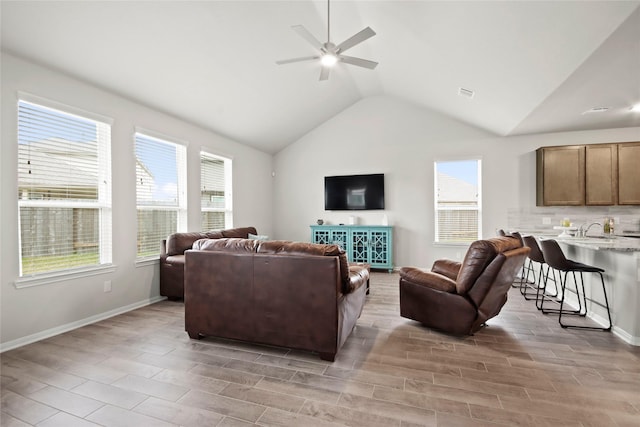 living room with ceiling fan, sink, and vaulted ceiling