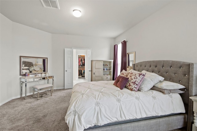 carpeted bedroom with a walk in closet