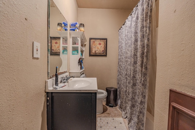 bathroom featuring vanity, tile patterned flooring, and toilet