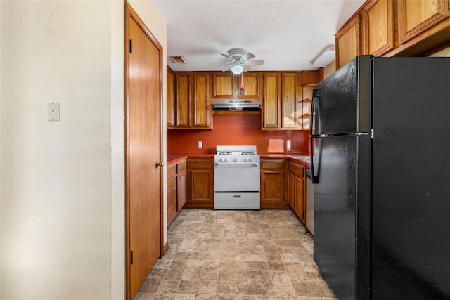 kitchen featuring ceiling fan, gas range gas stove, a textured ceiling, and black fridge