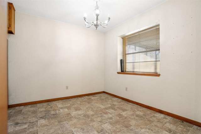 spare room featuring a chandelier