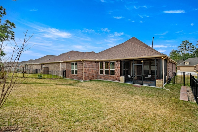 rear view of house with a sunroom and a lawn