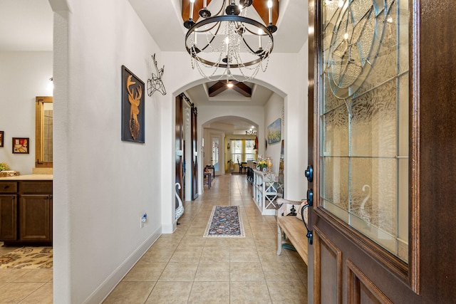 foyer featuring coffered ceiling, a chandelier, beam ceiling, and light tile patterned flooring