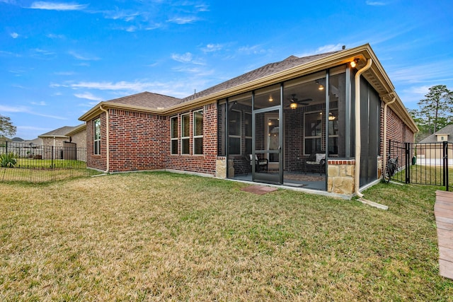 rear view of property with a sunroom, a yard, and ceiling fan