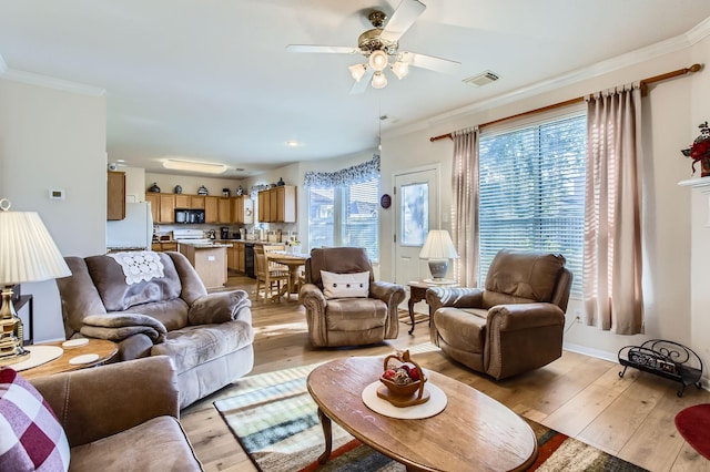 living room featuring ornamental molding, ceiling fan, and light hardwood / wood-style floors