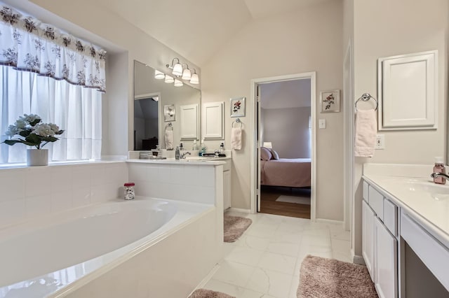 bathroom with lofted ceiling, vanity, and a bathtub