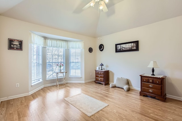 interior space with ceiling fan, lofted ceiling, and light hardwood / wood-style floors