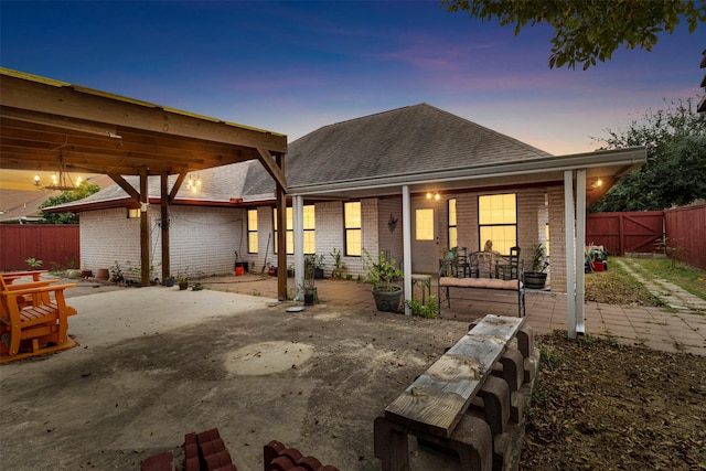 back house at dusk with a patio