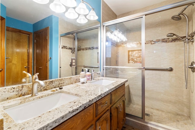 bathroom with a shower with shower door and vanity