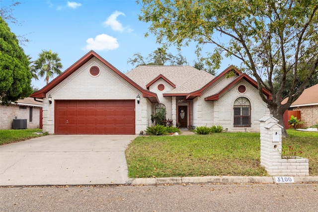 view of front of home featuring a front yard, central AC, and a garage