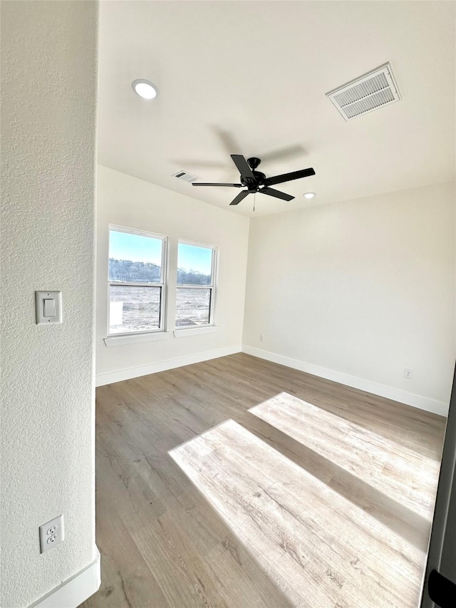 empty room with ceiling fan and wood-type flooring