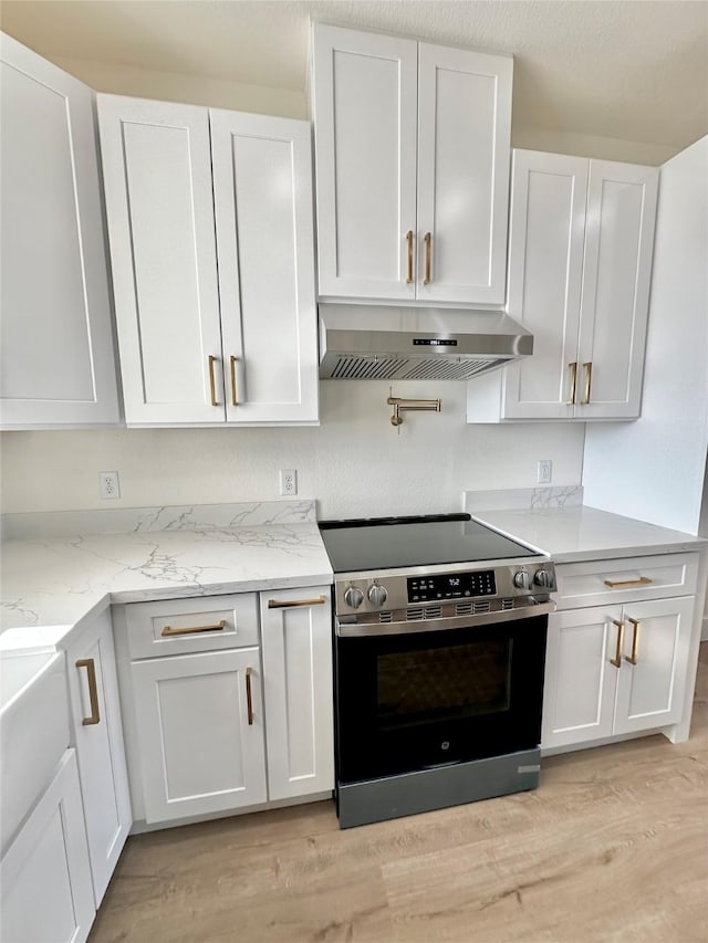 kitchen featuring white cabinets, extractor fan, and stainless steel range with electric cooktop