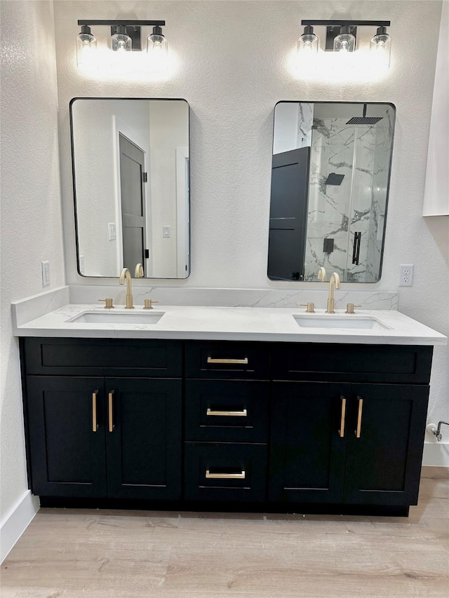 bathroom with hardwood / wood-style floors, walk in shower, and vanity