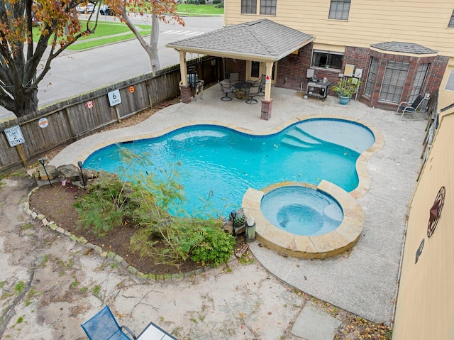 view of swimming pool featuring an in ground hot tub and a patio