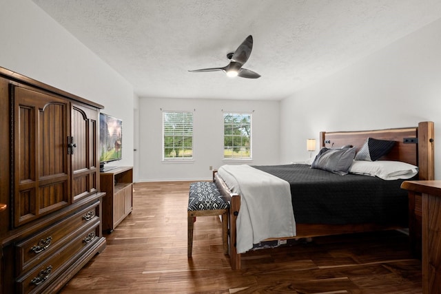 bedroom with dark hardwood / wood-style floors, a textured ceiling, and ceiling fan