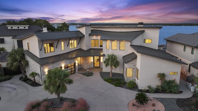 view of front of home with a water view and central AC