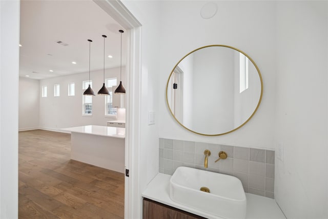 bathroom featuring hardwood / wood-style flooring, vanity, and tile walls