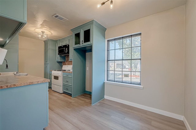 kitchen with white gas range, light hardwood / wood-style flooring, and green cabinetry