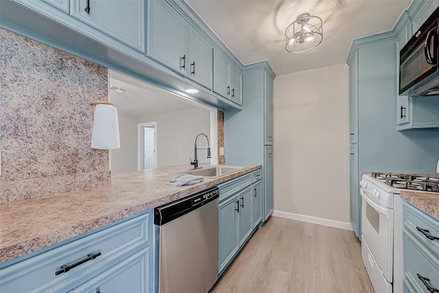 kitchen with light countertops, white gas stove, stainless steel dishwasher, black microwave, and a sink