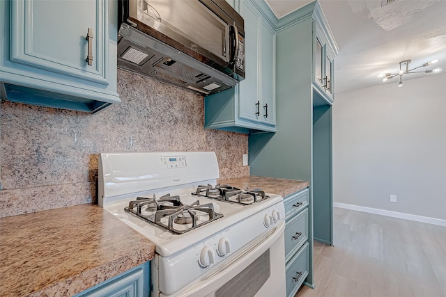 kitchen with blue cabinets, white gas stove, backsplash, and light hardwood / wood-style flooring