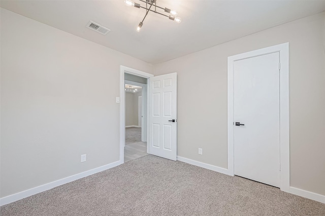 unfurnished bedroom featuring light carpet, visible vents, and baseboards