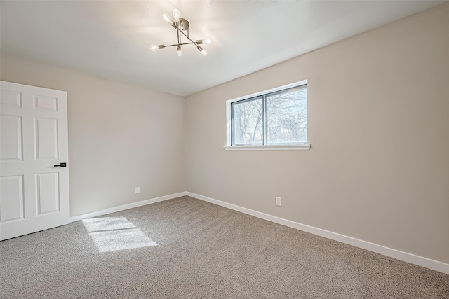 spare room featuring an inviting chandelier and carpet floors