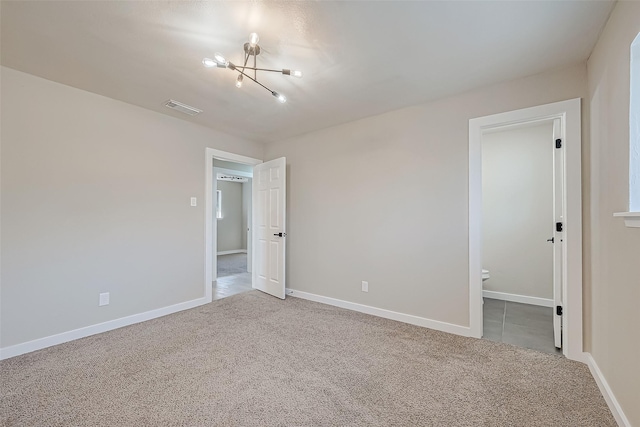 spare room featuring baseboards, visible vents, and carpet flooring