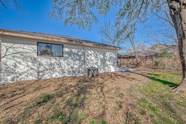 view of side of property featuring fence and a lawn