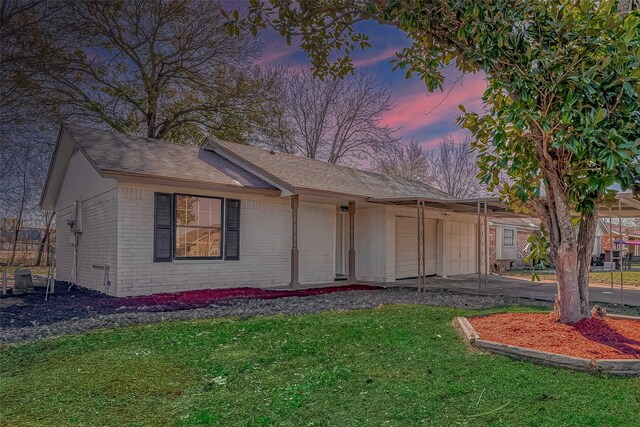 view of front of property featuring a garage, driveway, a front yard, and brick siding