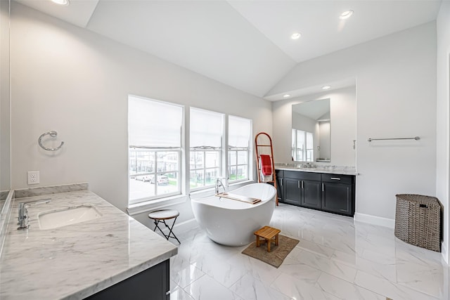 bathroom featuring a washtub, vaulted ceiling, and vanity