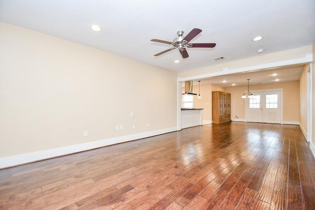 unfurnished living room with ceiling fan and wood-type flooring