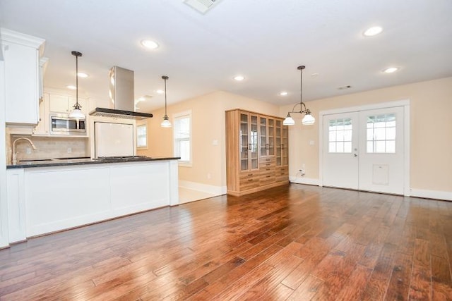 unfurnished living room with sink, hardwood / wood-style flooring, and french doors