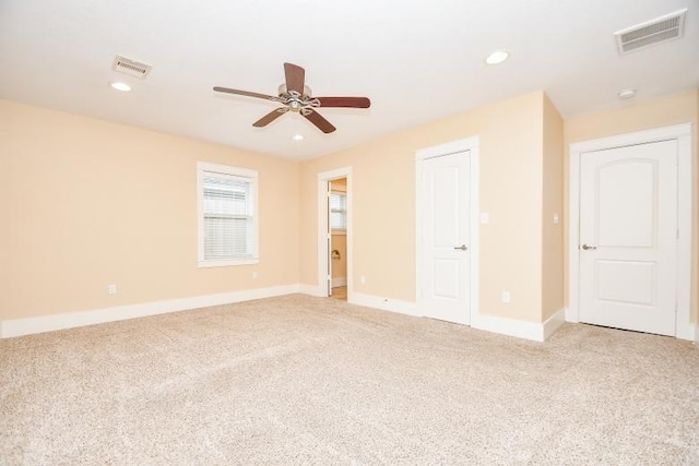 spare room featuring ceiling fan and light carpet