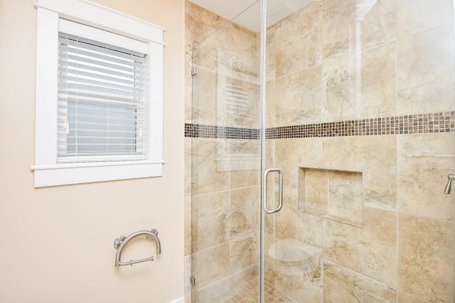 bathroom featuring a shower with door