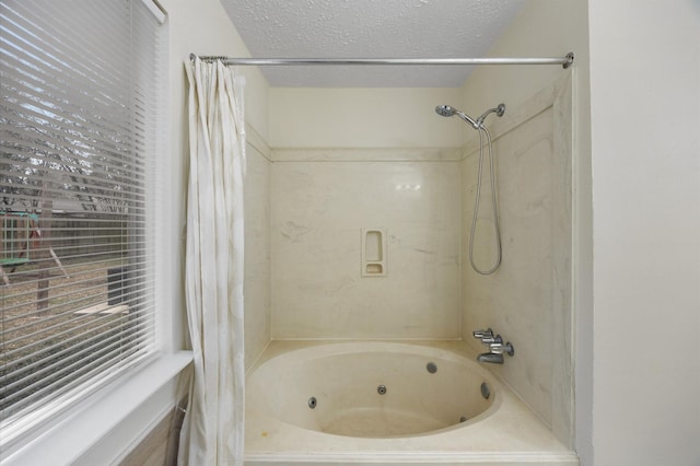 bathroom with shower / bathtub combination with curtain and a textured ceiling