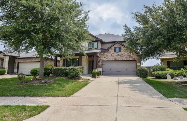 view of front of house with driveway, a garage, stone siding, a front yard, and brick siding